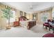 Spacious bedroom featuring a wooden bed frame, neutral carpet, and bright natural light at 11610 Grove Arcade Dr, Riverview, FL 33569