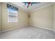Bright bedroom with neutral walls, plush carpeting, and a fun ceiling fan, creating a comfortable and playful space at 11610 Grove Arcade Dr, Riverview, FL 33569