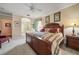 Bedroom features a wooden bed frame, neutral carpet, and bedside tables with lamps at 11610 Grove Arcade Dr, Riverview, FL 33569