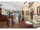 Open-concept dining area with wood floors, elegant glass table, and views of living spaces at 11610 Grove Arcade Dr, Riverview, FL 33569
