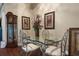 Stylish dining area features a glass table, ornate chairs, grandfather clock, and artistic décor at 11610 Grove Arcade Dr, Riverview, FL 33569