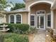 Inviting entrance with arched windows, glass paneled front door, and lush landscaping at 11610 Grove Arcade Dr, Riverview, FL 33569