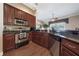 Well-equipped kitchen featuring stainless steel appliances, granite countertops, and wood cabinets at 11610 Grove Arcade Dr, Riverview, FL 33569