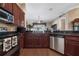 Well-equipped kitchen featuring stainless steel appliances, granite countertops, and wood cabinets at 11610 Grove Arcade Dr, Riverview, FL 33569