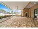 Spacious screened patio with brick flooring and a view of a gazebo, perfect for outdoor relaxation and entertainment at 11610 Grove Arcade Dr, Riverview, FL 33569