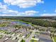 Serene community featuring modern homes with lush landscaping and a tranquil lake view, all under a bright blue sky at 13027 Pennybrook Dr, Riverview, FL 33579