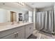 Well-lit bathroom with dual sinks, modern vanity, and a shower with a stylish curtain at 13027 Pennybrook Dr, Riverview, FL 33579