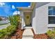 Close-up of a home's entryway, featuring a bright yellow door and meticulously arranged mulch beds at 13027 Pennybrook Dr, Riverview, FL 33579