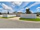 Home exterior featuring a two-car garage, green lawn, and white fence in a residential neighborhood at 13027 Pennybrook Dr, Riverview, FL 33579