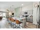 Modern kitchen featuring a large island with bar seating, stainless steel appliances, and a stylish geometric accent wall at 13027 Pennybrook Dr, Riverview, FL 33579