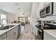 Contemporary kitchen with stainless steel appliances, shaker cabinets, and a convenient island with a sink and plenty of counter space at 13027 Pennybrook Dr, Riverview, FL 33579