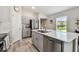 Well-lit kitchen boasts a spacious island with stainless steel dishwasher and sink, stainless appliances, and modern cabinetry at 13027 Pennybrook Dr, Riverview, FL 33579