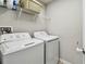 Functional laundry room equipped with a washer, dryer, and overhead shelving for efficient storage at 13027 Pennybrook Dr, Riverview, FL 33579