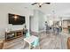 Open-concept living space featuring wood-look floors, entertainment center, and seamless transition to the dining area at 13027 Pennybrook Dr, Riverview, FL 33579