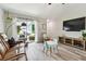 Bright living room with wood-look flooring, comfortable seating, and sliding glass doors to the outdoor patio at 13027 Pennybrook Dr, Riverview, FL 33579