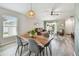 Open-concept living area featuring wood-look floors, a dining table, and a comfortable seating area with a leather sofa at 13027 Pennybrook Dr, Riverview, FL 33579
