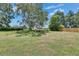 Expansive backyard with lush lawn, mature trees, and fencing, offering a serene and private outdoor space at 1309 Sandalwood Dr, Plant City, FL 33563