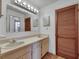 Bathroom with double sinks, neutral countertop, and wood door to toilet and shower area at 1309 Sandalwood Dr, Plant City, FL 33563