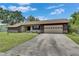 Single-story home featuring a well-maintained lawn and a concrete driveway leading to a garage at 1309 Sandalwood Dr, Plant City, FL 33563