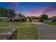 Charming single-story home with a well-maintained lawn with pink sunset at 1309 Sandalwood Dr, Plant City, FL 33563