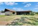 Back exterior of the home showing a large lawn, mature trees, landscaping, and a screened porch at 1309 Sandalwood Dr, Plant City, FL 33563