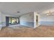 Open living area with sliding glass doors, neutral carpeting, and access to multiple rooms at 1309 Sandalwood Dr, Plant City, FL 33563