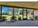 Covered and screened patio overlooking a sprawling backyard with mature trees and green grass at 1309 Sandalwood Dr, Plant City, FL 33563