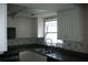 Bright kitchen with a stainless steel sink, white cabinetry, and dark countertops at 13627 San Rafael Dr, Largo, FL 33774