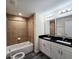 Bathroom featuring double sinks, granite countertops, and shower and tub with brown tile surround at 1557 S Martin Luther King Jr Ave, Clearwater, FL 33756