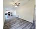 A spacious, open-plan living room with modern grey wood-look flooring adjacent to the kitchen at 1557 S Martin Luther King Jr Ave, Clearwater, FL 33756