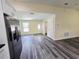 Open-concept living area with durable wood-look floors, stainless steel fridge and access to the front door at 1557 S Martin Luther King Jr Ave, Clearwater, FL 33756