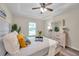 Comfortable bedroom featuring a ceiling fan, light wood furnishings, and view of landscaped backyard at 1561 S Martin Luther King Jr Ave, Clearwater, FL 33756