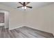 Cozy bedroom featuring gray wood-look floors, neutral walls, and a ceiling fan at 1561 S Martin Luther King Jr Ave, Clearwater, FL 33756