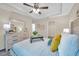 Bedroom featuring neutral decor, tray ceiling, ceiling fan, and a glimpse into the walk-in closet at 1561 S Martin Luther King Jr Ave, Clearwater, FL 33756
