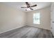Sunlit bedroom with gray floors, a ceiling fan, a window, and a closet at 1561 S Martin Luther King Jr Ave, Clearwater, FL 33756