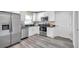 Modern kitchen features stainless steel appliances, white cabinets, and gray wood-look flooring at 1561 S Martin Luther King Jr Ave, Clearwater, FL 33756