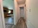 Hallway displaying wood-look flooring with a kitchen view at 1619 E Nome St, Tampa, FL 33604