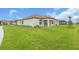 Spacious backyard with lush green lawn and a modern one-story home featuring a red tile roof at 17415 Holly Well Ave, Wimauma, FL 33598