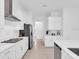 Modern kitchen with stainless appliances, sleek white cabinets, and a functional island counter at 17415 Holly Well Ave, Wimauma, FL 33598