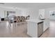 Open-concept kitchen with stainless steel appliances and dining area featuring an elegant table and chairs at 17415 Holly Well Ave, Wimauma, FL 33598