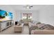 Bright living room features neutral tones, tile floors, and a large sectional sofa at 17415 Holly Well Ave, Wimauma, FL 33598