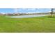 Expansive pond view surrounded by lush green grass and well-manicured lawns in a serene community at 17415 Holly Well Ave, Wimauma, FL 33598