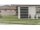 Close-up of a window with horizontal blinds and green grass outside at 17415 Holly Well Ave, Wimauma, FL 33598