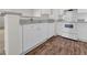 Bright kitchen with white cabinets, stainless sink and dark wood flooring at 18001 Richmond Place Dr # 116, Tampa, FL 33647