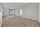 Neutral carpeted living room featuring a sliding glass door and ample space for relaxation at 18001 Richmond Place Dr # 116, Tampa, FL 33647