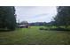 Exterior shot showcasing a barn with verdant surroundings, enhancing the property's rural charm and rustic appeal at 21451 Us Highway 98, Dade City, FL 33523