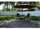 Inviting backyard patio with paved surface, umbrella-covered seating, and a white fence backdrop at 3212 Stevenson St, Plant City, FL 33566