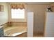 Bathroom featuring a soaking tub, walk-in shower, and window with a floral valance at 3212 Stevenson St, Plant City, FL 33566