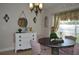 A dining room featuring a round wooden table, pink chairs, and a window with floral curtains at 3212 Stevenson St, Plant City, FL 33566
