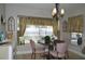 Bright dining area with floral curtains, round table, decorative chandelier, and neutral walls at 3212 Stevenson St, Plant City, FL 33566